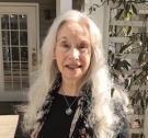 Louise Hawes ’65 standing in front of her home.